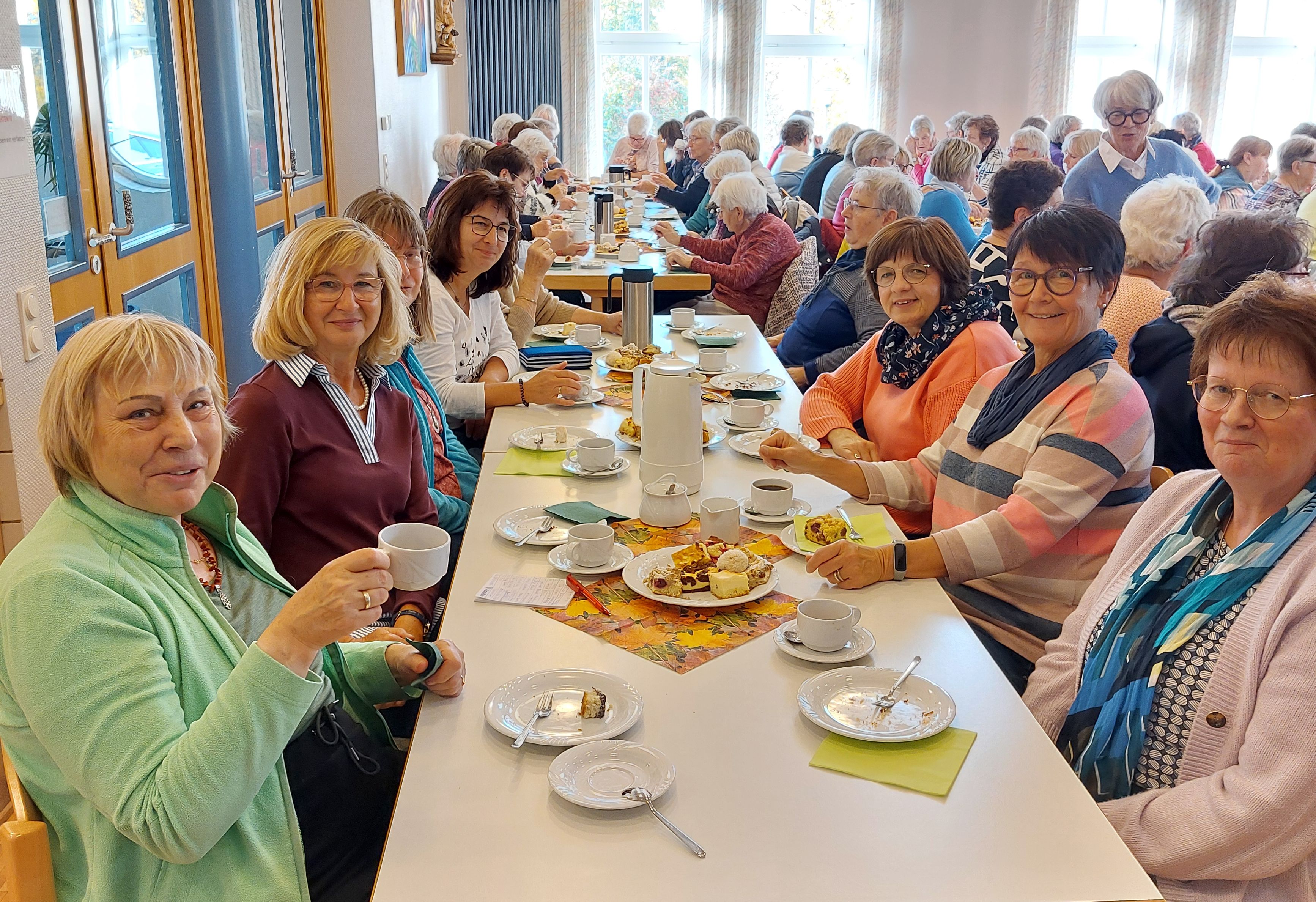 Viele Frauen sitzen fröhlich an einer Kaffeetafel